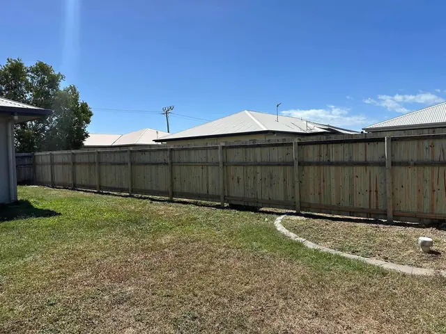 Old grey palings beside a new treated pine fence