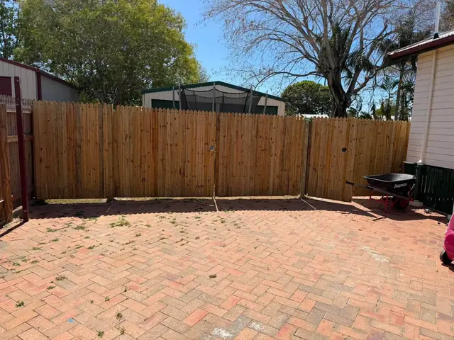 A new paling fence along a side path with a gate at the end